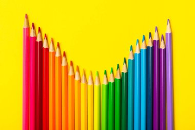 Renkli arka planda renkli kalemler. Boyama için ekipman. Yaratıcılık için kırtasiye malzemesi. Okula dönüyorum. Flatlay. Çocukların Yaratıcılığı ve Eğitimi. Rainbow.Mesaj için yer var. Boşluğu kopyala.