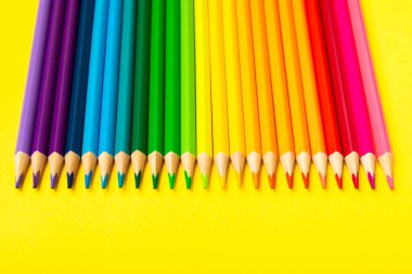 Renkli arka planda renkli kalemler. Boyama için ekipman. Yaratıcılık için kırtasiye malzemesi. Okula dönüyorum. Flatlay. Çocukların Yaratıcılığı ve Eğitimi. Rainbow.Mesaj için yer var. Boşluğu kopyala.