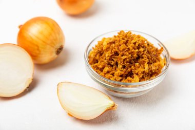 Tahta bir masada kasede kızarmış soğan. Kızarmış soğan. Bulaşık çeşnisi. Baharatlar. Salata sosu. Mesaj için yer var. Boşluğu kopyala