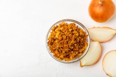 Tahta bir masada kasede kızarmış soğan. Kızarmış soğan. Bulaşık çeşnisi. Baharatlar. Salata sosu. Mesaj için yer var. Boşluğu kopyala