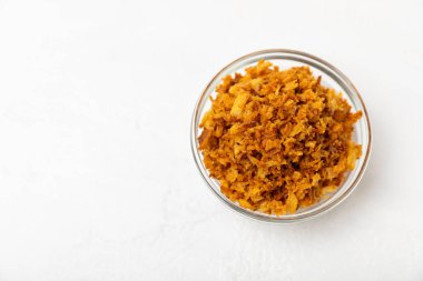 Tahta bir masada kasede kızarmış soğan. Kızarmış soğan. Bulaşık çeşnisi. Baharatlar. Salata sosu. Mesaj için yer var. Boşluğu kopyala