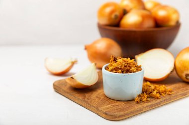 Tahta bir masada kasede kızarmış soğan. Kızarmış soğan. Bulaşık çeşnisi. Baharatlar. Salata sosu. Mesaj için yer var. Boşluğu kopyala