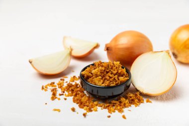 Tahta bir masada kasede kızarmış soğan. Kızarmış soğan. Bulaşık çeşnisi. Baharatlar. Salata sosu. Mesaj için yer var. Boşluğu kopyala