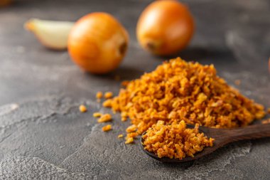 Tahta bir masada kasede kızarmış soğan. Kızarmış soğan. Bulaşık çeşnisi. Baharatlar. Salata sosu. Mesaj için yer var. Boşluğu kopyala