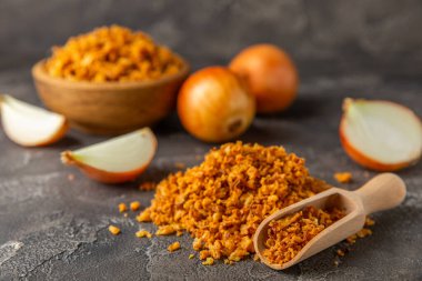 Tahta bir masada kasede kızarmış soğan. Kızarmış soğan. Bulaşık çeşnisi. Baharatlar. Salata sosu. Mesaj için yer var. Boşluğu kopyala