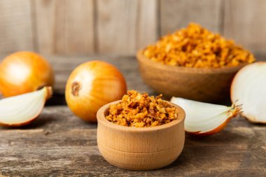 Tahta bir masada kasede kızarmış soğan. Kızarmış soğan. Bulaşık çeşnisi. Baharatlar. Salata sosu. Mesaj için yer var. Boşluğu kopyala