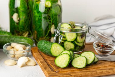 Ahşap bir arka planda kavanozda taze tuzlanmış ev yapımı salatalıklar. Dereotlu, sarımsaklı ve biberli salatalık turşusu. Konserve salatalık, salatalık ve penis. Ev yapımı koruma..