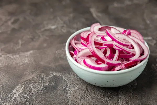 Mutfak masasında Shallot soğanı. Soğan dilimi. Soğan halkaları. Taze kırmızı soğan. Doğal, taze, vejetaryen yiyecekler. Tarım ürünleri. Sağlıklı beslenme. Sebzeler. Çiftçi pazarı..