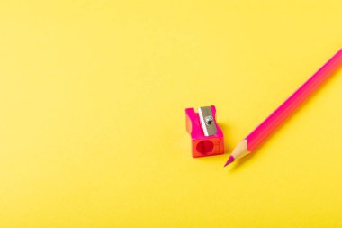 Renkli arka planda kalem açacağı. Kalem ve kalem talaşı. Kırtasiye malzemeleri. Okul malzemeleri. Okul ürünleri. Düz yatıyordu. Mesaj için yer. Boşluğu kopyala.