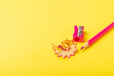 Renkli arka planda kalem açacağı. Kalem ve kalem talaşı. Kırtasiye malzemeleri. Okul malzemeleri. Okul ürünleri. Düz yatıyordu. Mesaj için yer. Boşluğu kopyala.