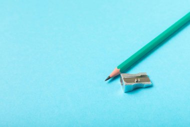 Renkli arka planda kalem açacağı. Kalem ve kalem talaşı. Kırtasiye malzemeleri. Okul malzemeleri. Okul ürünleri. Düz yatıyordu. Mesaj için yer. Boşluğu kopyala.