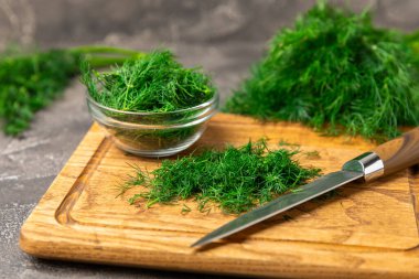Ahşap arka planda Dill. Taze organik sebzeler. Dill çiftliği. Dereotu yapraklarını kes. Bahar genç deresi sürüsü. Vitaminler. İplik. Aromatik mutfak baharatı. Mesaj için yer. Boşluğu kopyala