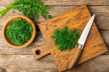 Ahşap arka planda Dill. Taze organik sebzeler. Dill çiftliği. Dereotu yapraklarını kes. Bahar genç deresi sürüsü. Vitaminler. İplik. Aromatik mutfak baharatı. Mesaj için yer. Boşluğu kopyala