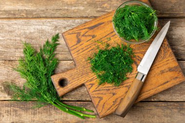 Ahşap arka planda Dill. Taze organik sebzeler. Dill çiftliği. Dereotu yapraklarını kes. Bahar genç deresi sürüsü. Vitaminler. İplik. Aromatik mutfak baharatı. Mesaj için yer. Boşluğu kopyala