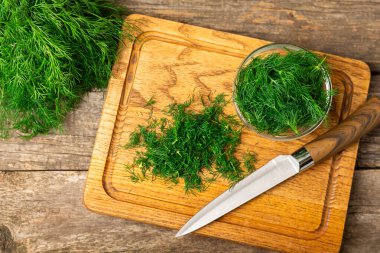 Ahşap arka planda Dill. Taze organik sebzeler. Dill çiftliği. Dereotu yapraklarını kes. Bahar genç deresi sürüsü. Vitaminler. İplik. Aromatik mutfak baharatı. Mesaj için yer. Boşluğu kopyala