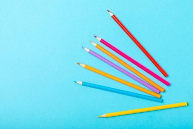 Renkli arka planda renkli kalemler. Boyama için ekipman. Yaratıcılık için kırtasiye malzemesi. Okula dönüyorum. Flatlay. Çocukların Yaratıcılığı ve Eğitimi. Rainbow.Mesaj için yer var. Boşluğu kopyala.