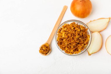 Tahta bir masada kasede kızarmış soğan. Kızarmış soğan. Bulaşık çeşnisi. Baharatlar. Salata sosu. Mesaj için yer var. Boşluğu kopyala