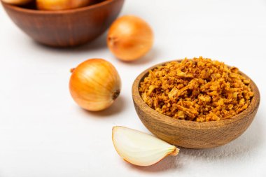 Tahta bir masada kasede kızarmış soğan. Kızarmış soğan. Bulaşık çeşnisi. Baharatlar. Salata sosu. Mesaj için yer var. Boşluğu kopyala