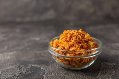 Tahta bir masada kasede kızarmış soğan. Kızarmış soğan. Bulaşık çeşnisi. Baharatlar. Salata sosu. Mesaj için yer var. Boşluğu kopyala