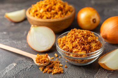 Tahta bir masada kasede kızarmış soğan. Kızarmış soğan. Bulaşık çeşnisi. Baharatlar. Salata sosu. Mesaj için yer var. Boşluğu kopyala