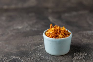 Tahta bir masada kasede kızarmış soğan. Kızarmış soğan. Bulaşık çeşnisi. Baharatlar. Salata sosu. Mesaj için yer var. Boşluğu kopyala