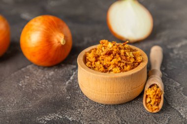 Tahta bir masada kasede kızarmış soğan. Kızarmış soğan. Bulaşık çeşnisi. Baharatlar. Salata sosu. Mesaj için yer var. Boşluğu kopyala