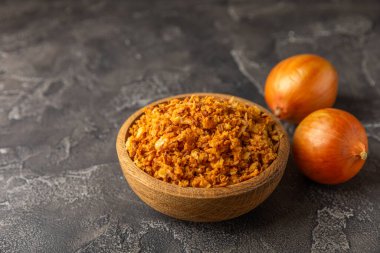 Tahta bir masada kasede kızarmış soğan. Kızarmış soğan. Bulaşık çeşnisi. Baharatlar. Salata sosu. Mesaj için yer var. Boşluğu kopyala