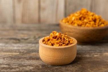 Tahta bir masada kasede kızarmış soğan. Kızarmış soğan. Bulaşık çeşnisi. Baharatlar. Salata sosu. Mesaj için yer var. Boşluğu kopyala