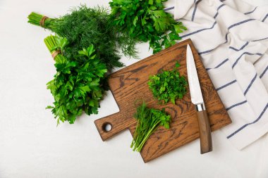 Doku masasında Dill ve Maydanoz. Maydanozla dereotu karıştırdım. Taze aromalı baharatlı sebzeler. Baharatlar ve bitkiler. Mesaj için yer var. Boşluğu kopyala