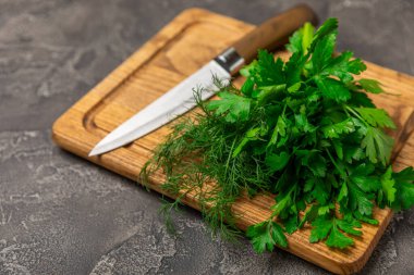 Doku masasında Dill ve Maydanoz. Maydanozla dereotu karıştırdım. Taze aromalı baharatlı sebzeler. Baharatlar ve bitkiler. Mesaj için yer var. Boşluğu kopyala