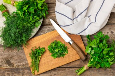 Doku masasında Dill ve Maydanoz. Maydanozla dereotu karıştırdım. Taze aromalı baharatlı sebzeler. Baharatlar ve bitkiler. Mesaj için yer var. Boşluğu kopyala