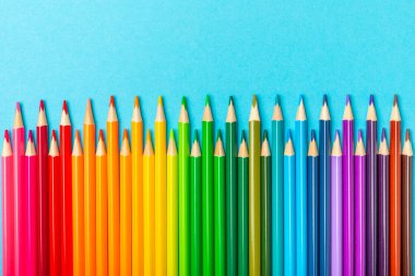 Renkli arka planda renkli kalemler. Boyama için ekipman. Yaratıcılık için kırtasiye malzemesi. Okula dönüyorum. Flatlay. Çocukların Yaratıcılığı ve Eğitimi. Rainbow.Mesaj için yer var. Boşluğu kopyala.