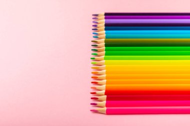 Renkli arka planda renkli kalemler. Boyama için ekipman. Yaratıcılık için kırtasiye malzemesi. Okula dönüyorum. Flatlay. Çocukların Yaratıcılığı ve Eğitimi. Rainbow.Mesaj için yer var. Boşluğu kopyala.