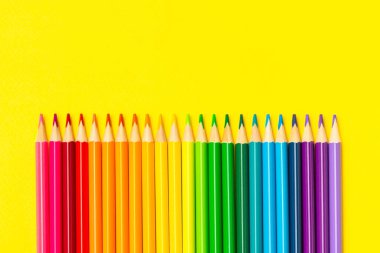 Renkli arka planda renkli kalemler. Boyama için ekipman. Yaratıcılık için kırtasiye malzemesi. Okula dönüyorum. Flatlay. Çocukların Yaratıcılığı ve Eğitimi. Rainbow.Mesaj için yer var. Boşluğu kopyala.