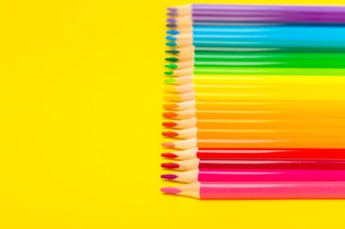 Renkli arka planda renkli kalemler. Boyama için ekipman. Yaratıcılık için kırtasiye malzemesi. Okula dönüyorum. Flatlay. Çocukların Yaratıcılığı ve Eğitimi. Rainbow.Mesaj için yer var. Boşluğu kopyala.