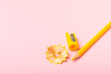 Renkli arka planda kalem açacağı. Kalem ve kalem talaşı. Kırtasiye malzemeleri. Okul malzemeleri. Okul ürünleri. Düz yatıyordu. Mesaj için yer. Boşluğu kopyala.