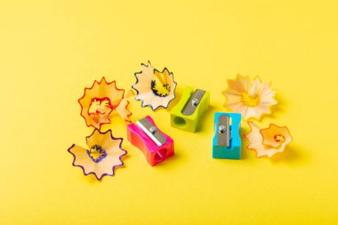 Renkli arka planda kalem açacağı. Kalem ve kalem talaşı. Kırtasiye malzemeleri. Okul malzemeleri. Okul ürünleri. Düz yatıyordu. Mesaj için yer. Boşluğu kopyala.