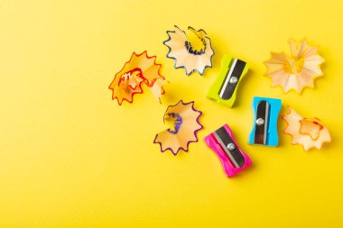 Renkli arka planda kalem açacağı. Kalem ve kalem talaşı. Kırtasiye malzemeleri. Okul malzemeleri. Okul ürünleri. Düz yatıyordu. Mesaj için yer. Boşluğu kopyala.