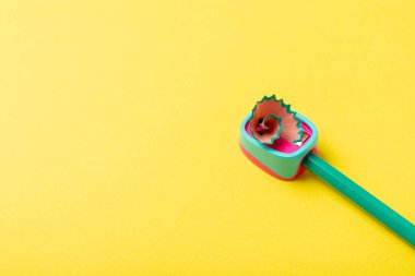 Renkli arka planda kalem açacağı. Kalem ve kalem talaşı. Kırtasiye malzemeleri. Okul malzemeleri. Okul ürünleri. Düz yatıyordu. Mesaj için yer. Boşluğu kopyala.