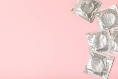 Renkli arka planda prezervatifler. Paketlemede renkli meyve temalı prezervatifler. Güvenli seks konsepti. Doğum kontrol hapı. Farklı doğum kontrol yöntemleri. AİDS önleme. Dünya AIDS Günü. Cinsel sağlık.