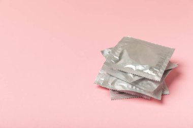 Renkli arka planda prezervatifler. Paketlemede renkli meyve temalı prezervatifler. Güvenli seks konsepti. Doğum kontrol hapı. Farklı doğum kontrol yöntemleri. AİDS önleme. Dünya AIDS Günü. Cinsel sağlık.