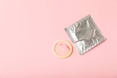 Renkli arka planda prezervatifler. Paketlemede renkli meyve temalı prezervatifler. Güvenli seks konsepti. Doğum kontrol hapı. Farklı doğum kontrol yöntemleri. AİDS önleme. Dünya AIDS Günü. Cinsel sağlık.