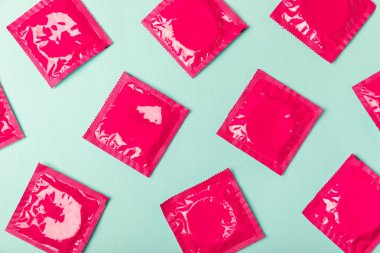 Renkli arka planda prezervatifler. Paketlemede renkli meyve temalı prezervatifler. Güvenli seks konsepti. Doğum kontrol hapı. Farklı doğum kontrol yöntemleri. AİDS önleme. Dünya AIDS Günü. Cinsel sağlık.