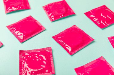 Renkli arka planda prezervatifler. Paketlemede renkli meyve temalı prezervatifler. Güvenli seks konsepti. Doğum kontrol hapı. Farklı doğum kontrol yöntemleri. AİDS önleme. Dünya AIDS Günü. Cinsel sağlık.