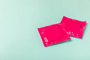 Renkli arka planda prezervatifler. Paketlemede renkli meyve temalı prezervatifler. Güvenli seks konsepti. Doğum kontrol hapı. Farklı doğum kontrol yöntemleri. AİDS önleme. Dünya AIDS Günü. Cinsel sağlık.