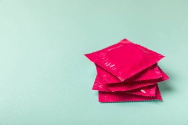 Renkli arka planda prezervatifler. Paketlemede renkli meyve temalı prezervatifler. Güvenli seks konsepti. Doğum kontrol hapı. Farklı doğum kontrol yöntemleri. AİDS önleme. Dünya AIDS Günü. Cinsel sağlık.