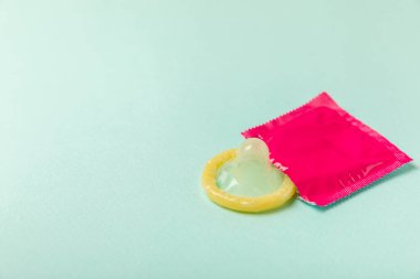 Renkli arka planda prezervatifler. Paketlemede renkli meyve temalı prezervatifler. Güvenli seks konsepti. Doğum kontrol hapı. Farklı doğum kontrol yöntemleri. AİDS önleme. Dünya AIDS Günü. Cinsel sağlık.