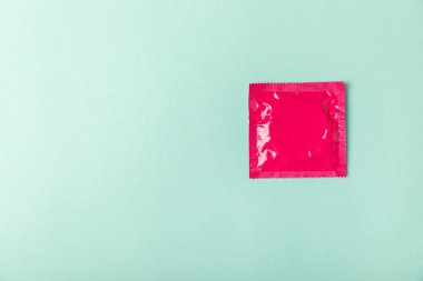 Renkli arka planda prezervatifler. Paketlemede renkli meyve temalı prezervatifler. Güvenli seks konsepti. Doğum kontrol hapı. Farklı doğum kontrol yöntemleri. AİDS önleme. Dünya AIDS Günü. Cinsel sağlık.