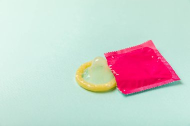 Renkli arka planda prezervatifler. Paketlemede renkli meyve temalı prezervatifler. Güvenli seks konsepti. Doğum kontrol hapı. Farklı doğum kontrol yöntemleri. AİDS önleme. Dünya AIDS Günü. Cinsel sağlık.