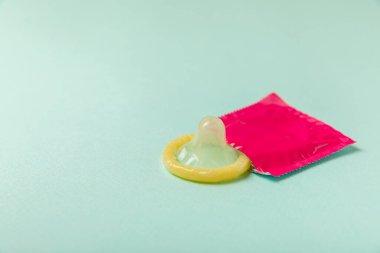 Renkli arka planda prezervatifler. Paketlemede renkli meyve temalı prezervatifler. Güvenli seks konsepti. Doğum kontrol hapı. Farklı doğum kontrol yöntemleri. AİDS önleme. Dünya AIDS Günü. Cinsel sağlık.